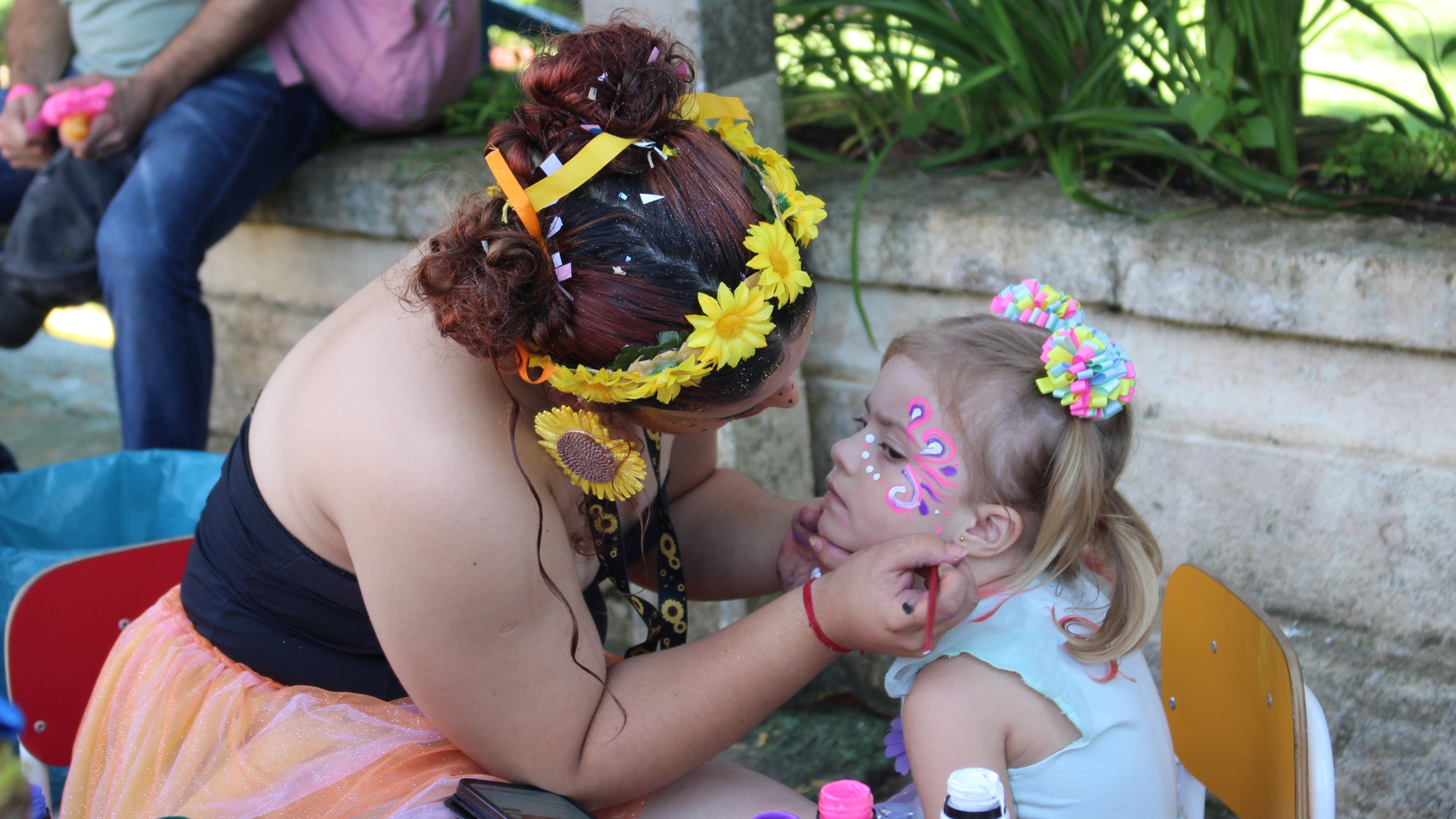 Mediadora faz pintura facial em criança durante atividade no Museu da Vida